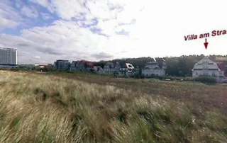 Aussicht über Dünen auf Promenade, Gebäude und Himmel in Warnemünde an der Ostsee