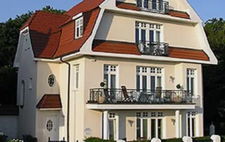 Repräsentative Außenansicht der Villa am Strand in Warnemünde mit gepflegter Fassade und Lage am Meer.