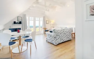 Zwei Sofas, Tisch, Essbereich mit rundem Tisch und Stühlen, Fenster im hellen Wohnbereich