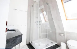 Modernes, helles Badezimmer mit Dusche, Waschtisch und Spiegel in der Ferienwohnung in Warnemünde