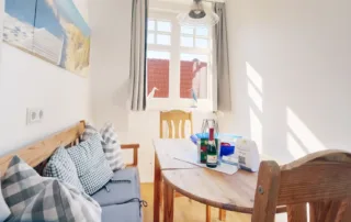 Lichtdurchfluteter Essbereich mit Sitzbank, Tisch, Stühlen und Fenster in der Ferienwohnung an der Ostsee