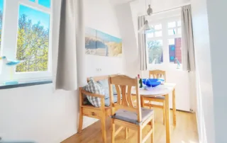 Küche mit Fenster, Essbereich und Stühlen in heller, einladender Gestaltung in der Ferienwohnung