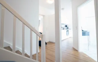 Flur mit Treppenaufgang, Durchgang zur Küche und Blick ins Badezimmer in der Ferienwohnung